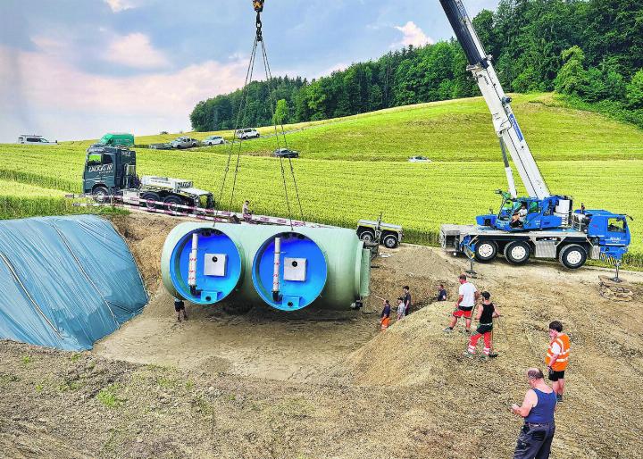 Der über fünf Tonnen schwere Technikraum mit den zwei Anschlüssen für die Wasserkammern baumelt über dem Sandbett, in dem er künftig ruhen wird. Bild: Marianne Burgener