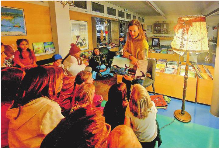 Nathalie Kägi liest den aufmerksamen Kindern die Geschichte von der kleinen Schnecke und dem grossen Buckelwal vor.
