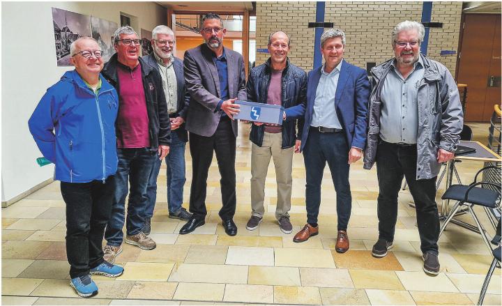 Peter Bühler, Roland Gahlinger, Andreas Sigrist, Markus Büsser, Ueli Graf und Roland Lienhard überreichen Gemeindepräsident Matthias Küng insgesamt 1116 Unterschriften gegen die Verdoppelung des Wasserpreises. Bild: Emanuela Manzari