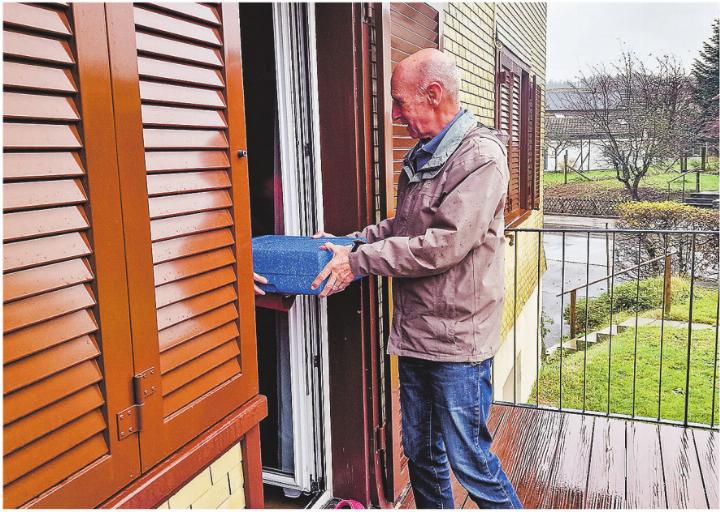 Hans-Peter Meier überreicht einer Klientin persönlich eine Mahlzeit. Bild: Emanuela Manzari