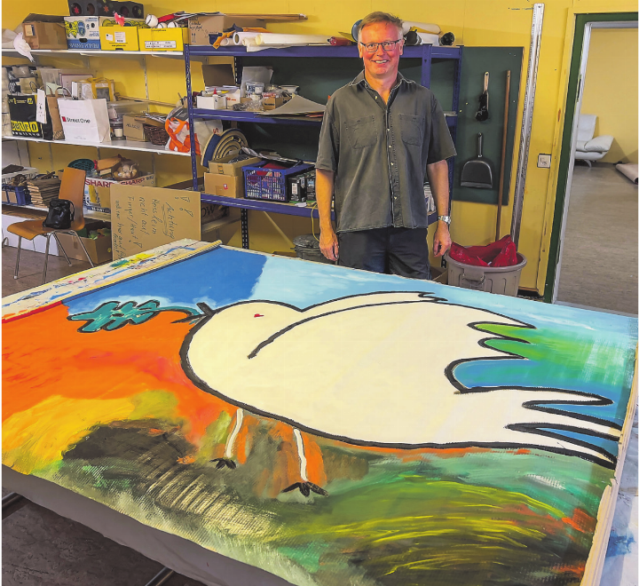 «Kunst & Kirche» in Elgg: Gemeindeleiter Jürgen Kaesler mit dem gemeinschaftlich gemalten Bild mit Friedenstaube. Bild: Bettina Sticher
