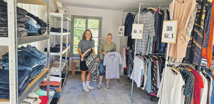 Agatha und Sonja Bisang zeigen in der «Chleidergarage» stolz die gut erhaltenen Kleidungsstücke.
